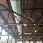 The industrial ceiling of Mintwood with black piping and aluminun venting.